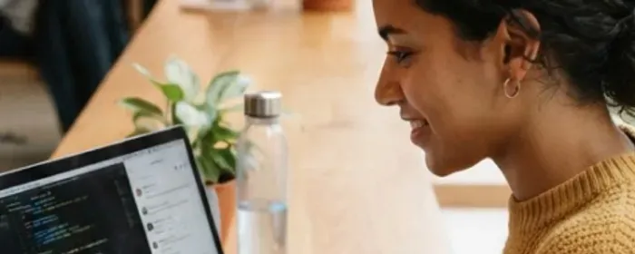 Une femme travaille sur son ordinateur portable dans un espace lumineux